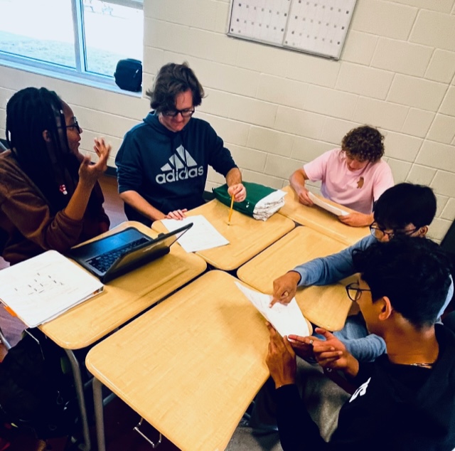 PreCalculus students Meso Ogwo, Nicholas Morse, Aidan Mueller, Suvas Nellore, and Jeon George (from left to right) work together and encourage each other on a difficult classwork assignment. 