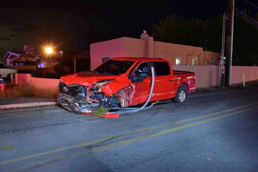 Police tape and emergency lights near a damaged truck crash scene in Mesilla